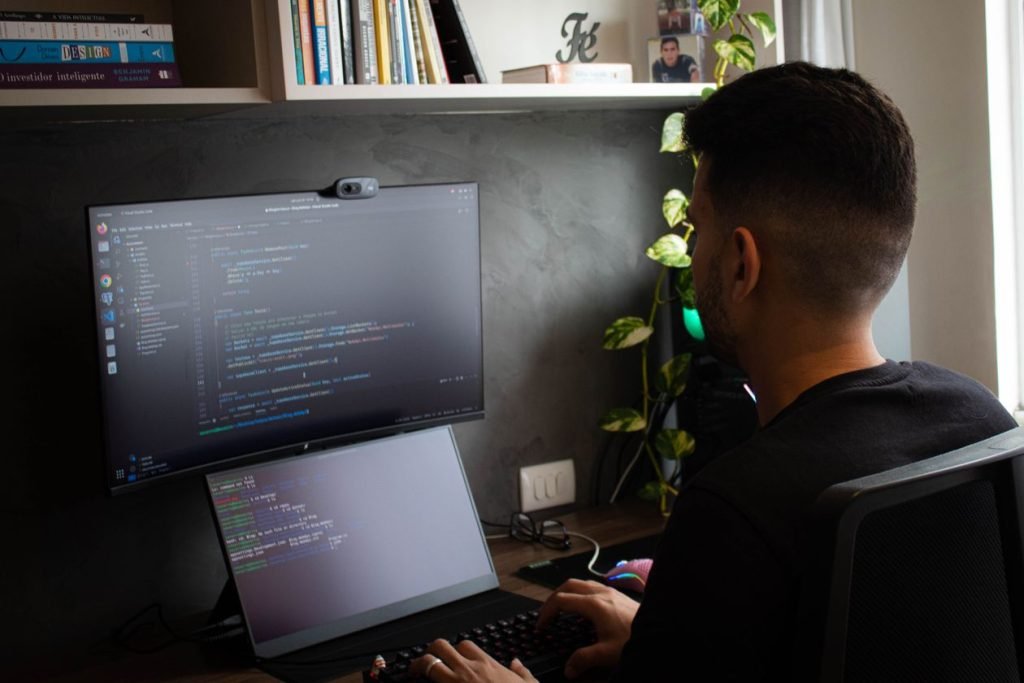 Programmer working on a laptop and monitor setup