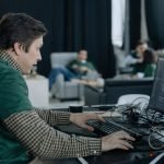 Software engineer coding at a computer in a modern office