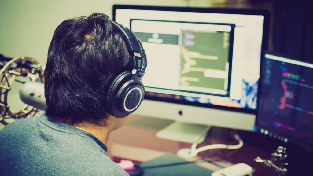Programmer focused on a dual-monitor coding setup