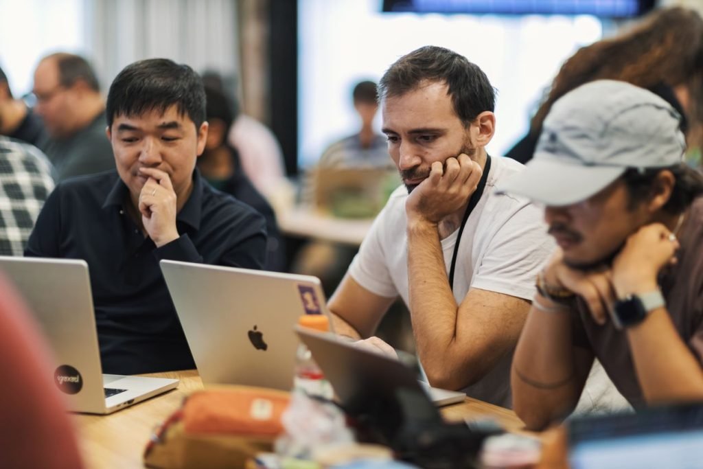 Team of professionals collaborating on laptops in an office